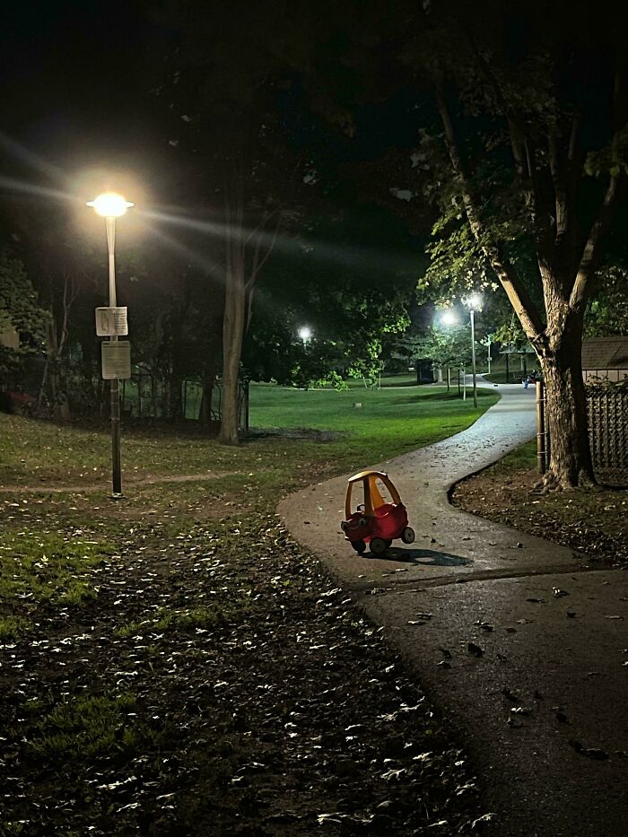 Toy car abandoned on a dimly lit park path at night, giving a creepy vibe people had to share with others.