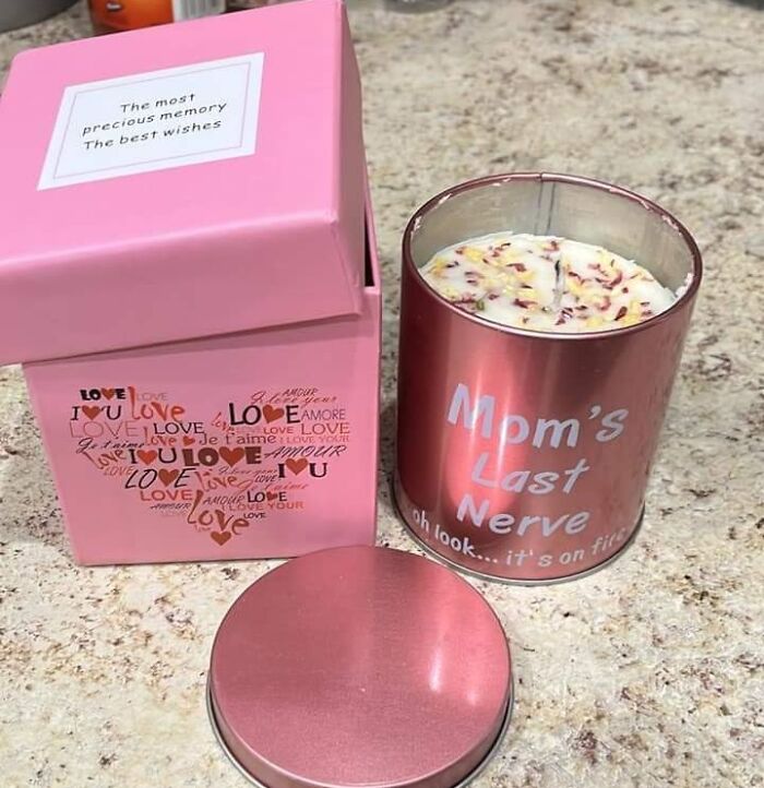 Rose gold candle labeled Mom's Last Nerve with floral wax next to a pink gift box with love-themed design, a last minute Mother's Day gift.