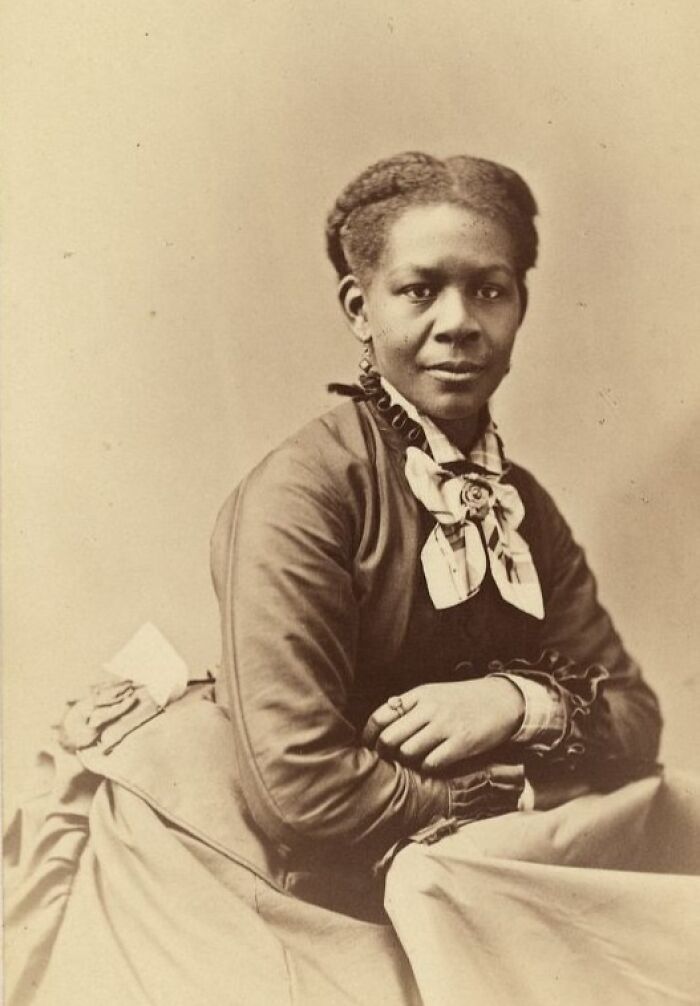 African American woman in 19th century dress, showcasing strength and resilience from a century ago in a historic portrait.