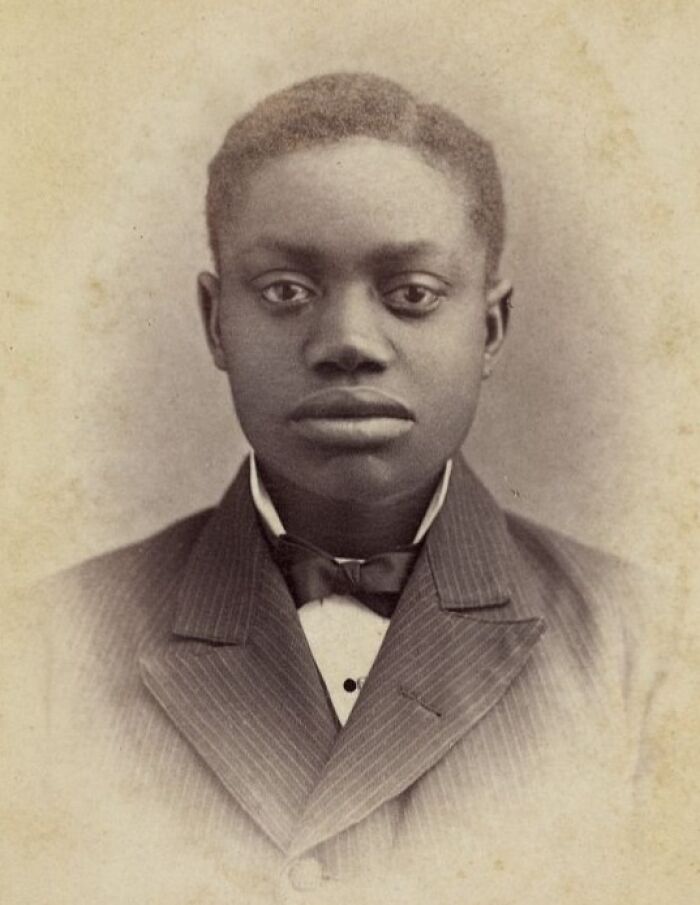 Portrait of a young African American man dressed in a suit and bow tie, showing strength and dignity from over a century ago.