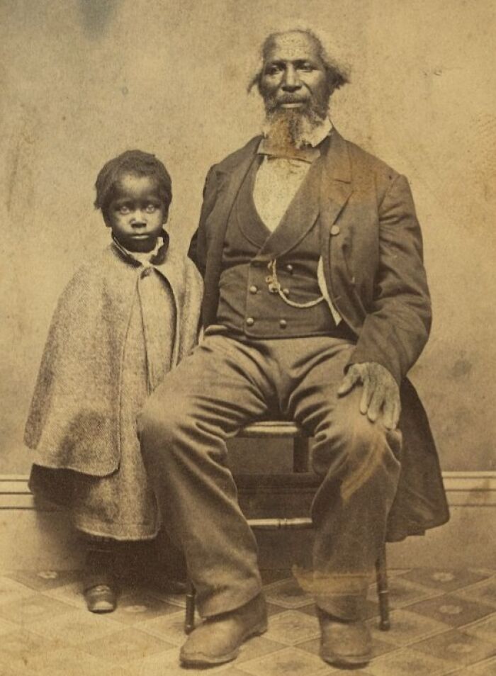 African American man and child from over a century ago, showcasing strength and resilience in historic photo.