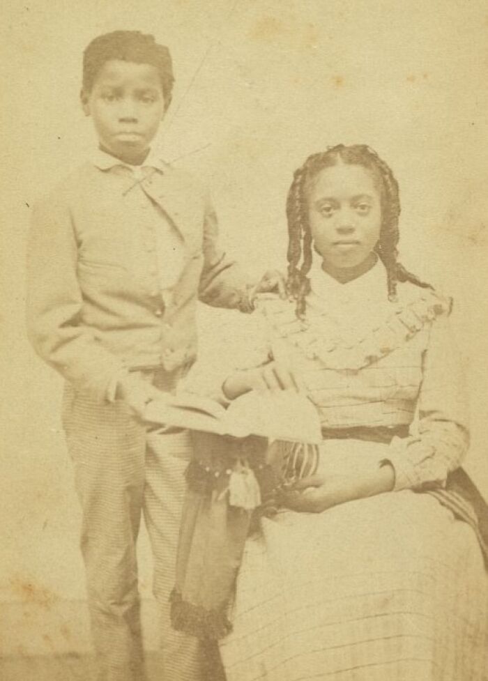 Vintage photo of two African American children dressed formally, representing strength from over a century ago.