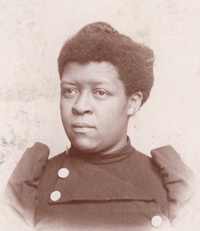Portrait of an African American woman showcasing strength and resilience from over a century ago in a vintage photograph.