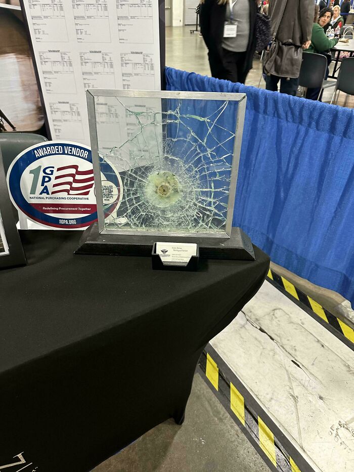 Bulletproof glass display with a shattered impact point, illustrating current life in the US through American perspectives.