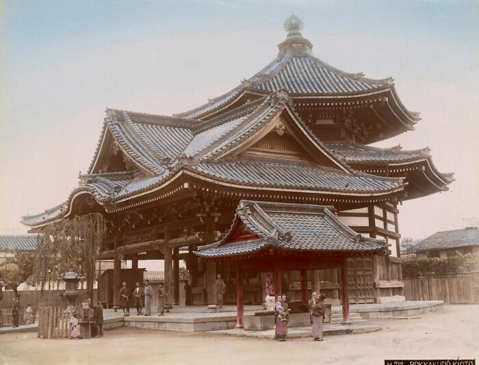 Traditional Japanese temple with people in historic clothing, showcasing architecture and daily life in 1800s Japan.