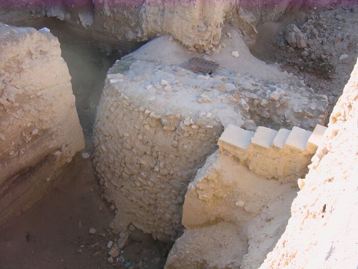 Ancient man-made stone structure partially excavated, showcasing historical construction techniques and archaeological significance.