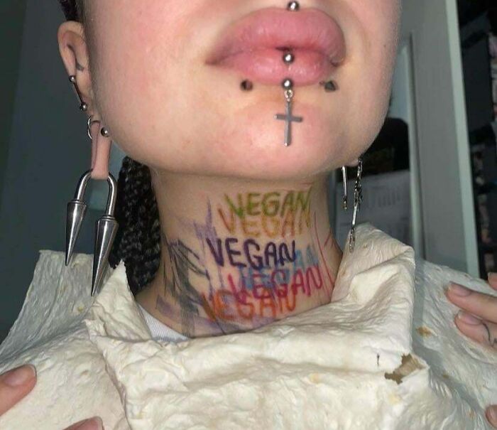 Neck tattoo with repeated misspelled word vegan in various colors showing a wild tattoo fail.