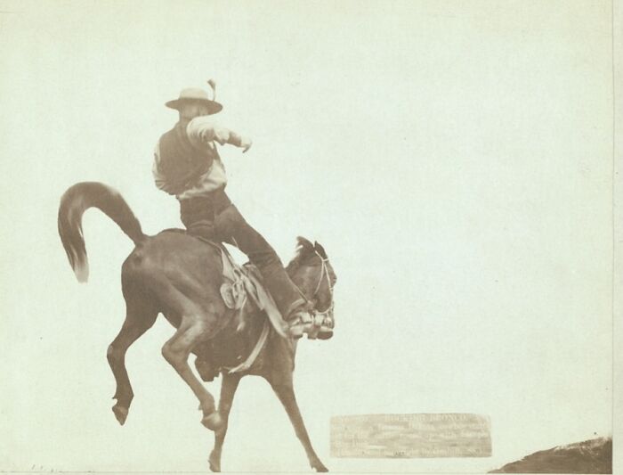 Cowboy riding a bucking horse in an authentic photo from the 1800s depicting cowboys and Native Americans.