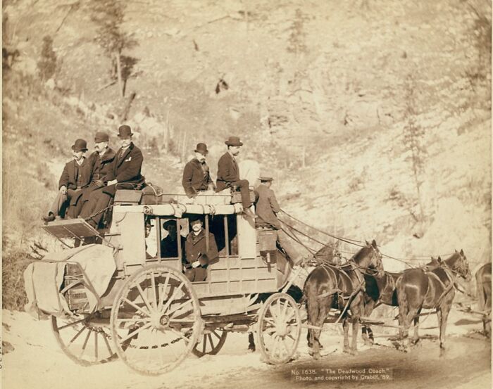 Horse-drawn stagecoach with passengers in 1800s landscape, illustrating authentic photos of cowboys and Native Americans.