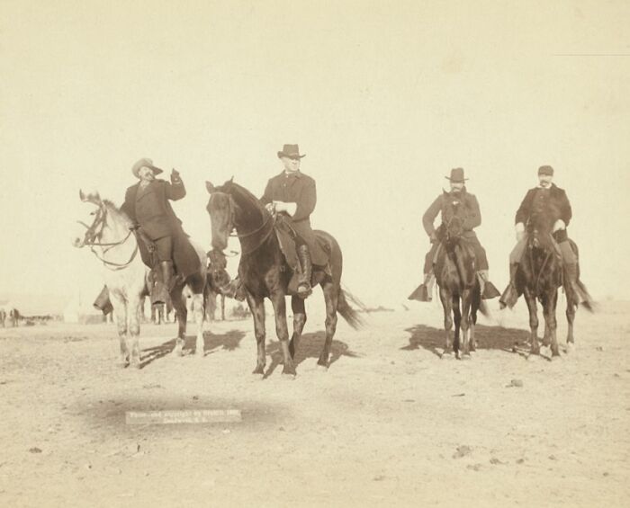 Four cowboys on horseback in an open area, showing authentic scenes of cowboys and Native Americans in the 1800s.