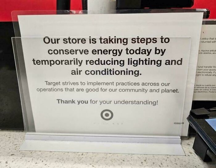 Store sign at checkout explains energy conservation by reducing lighting and air conditioning, reflecting current life in the US.