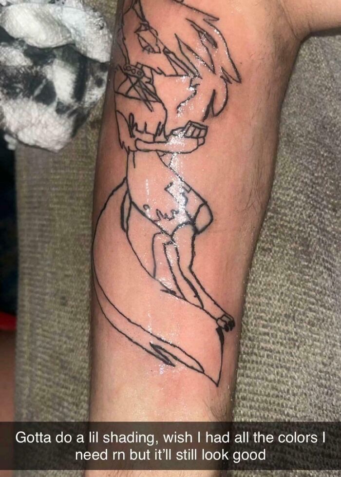 Tattoo fail on forearm showing a poorly drawn, unfinished animal design with minimal shading and outline only.