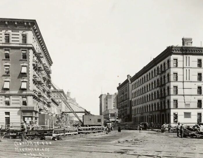 Black and white photo showing early 20th century life in America with construction and historic buildings in a city.