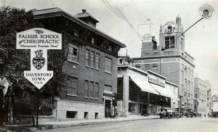 Street view of historic buildings in America featuring The Palmer School of Chiropractic in Davenport, showcasing life in America 100 years ago.