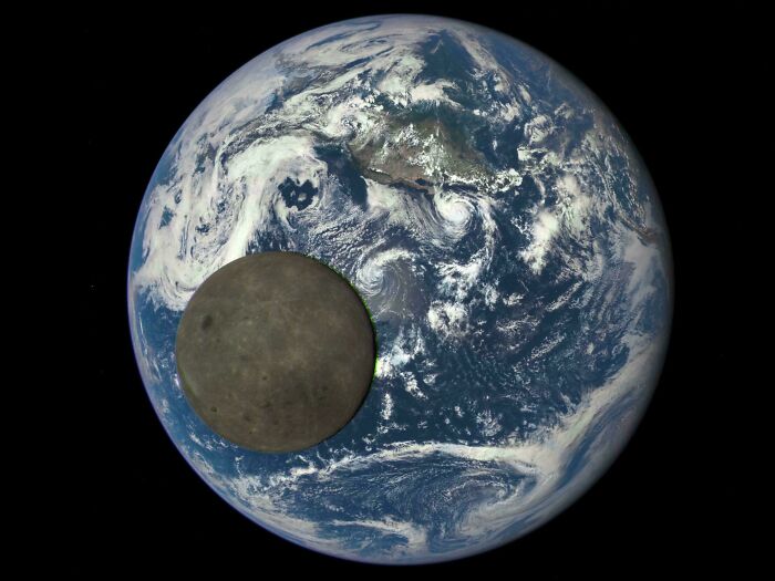 Alternate angle of Earth with the Moon partially covering the planet, showcasing iconic space event in history.
