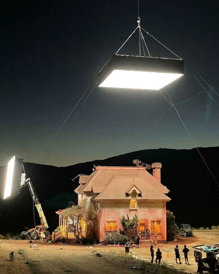 Film crew illuminating a house at night with large lights, showcasing alternate angles of iconic historical scenes.