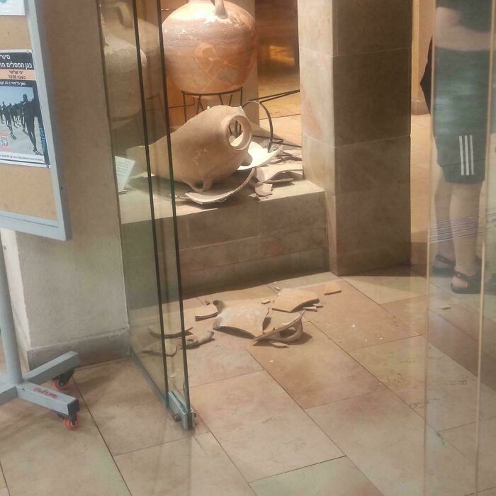 Broken ancient pottery on the floor of a museum caused by rude and obnoxious tourists damaging exhibits.