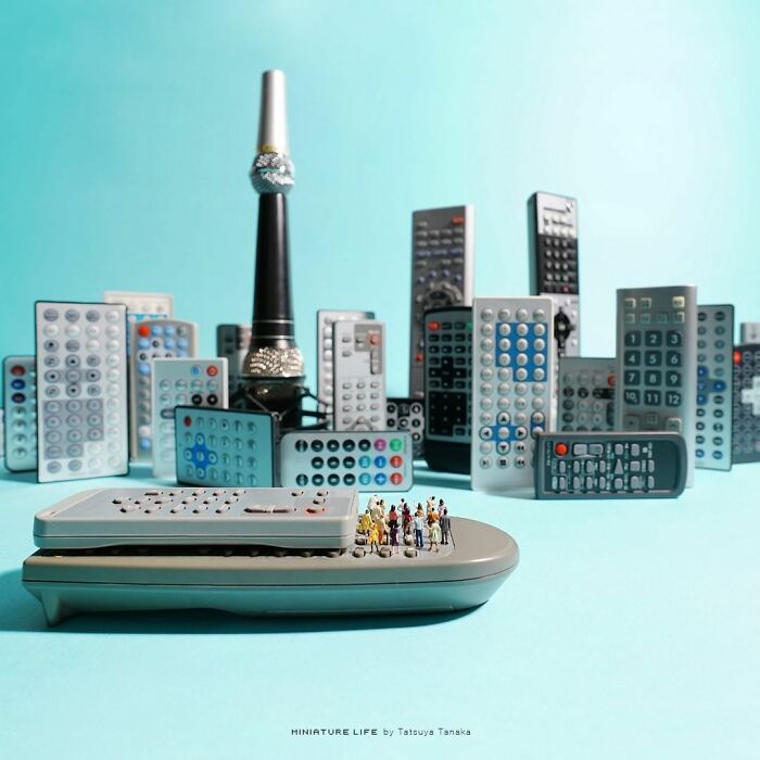 Miniatures on remote control resembling a city skyline with figurines in the foreground.