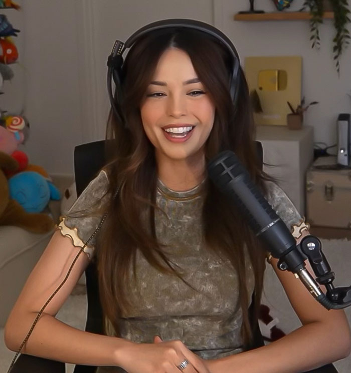 Streamer discussing 'Minecraft' scene and Jason Momoa's set behavior in her home studio setup, wearing headphones.