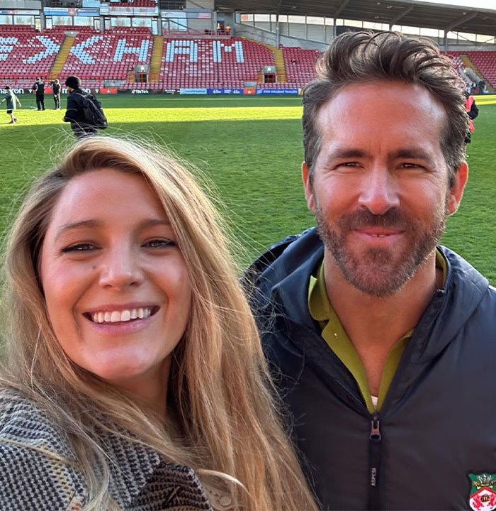 Happy couple taking a selfie on a football field.
