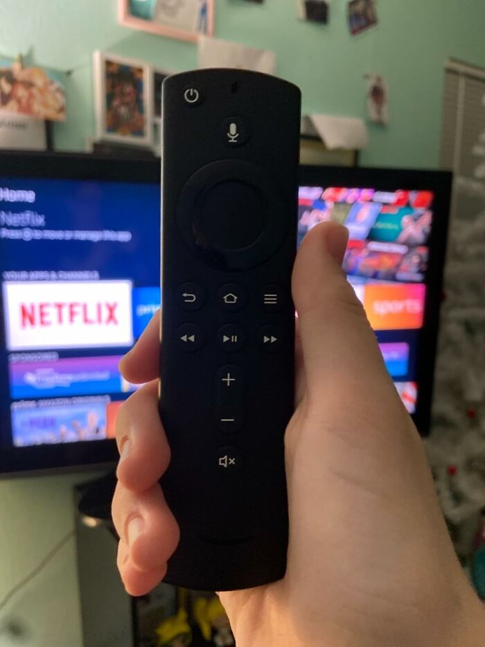 Smart home remote held in hand, controlling a streaming device on a TV screen displaying Netflix.