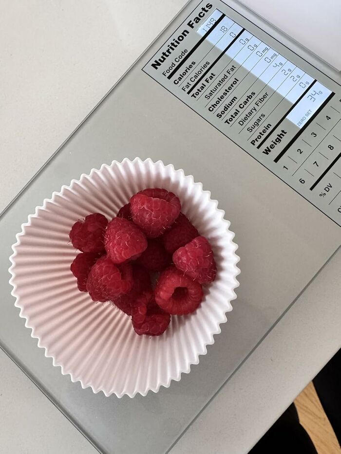 Raspberries in a paper cup on a food scale, ideal for efficient meal prep.