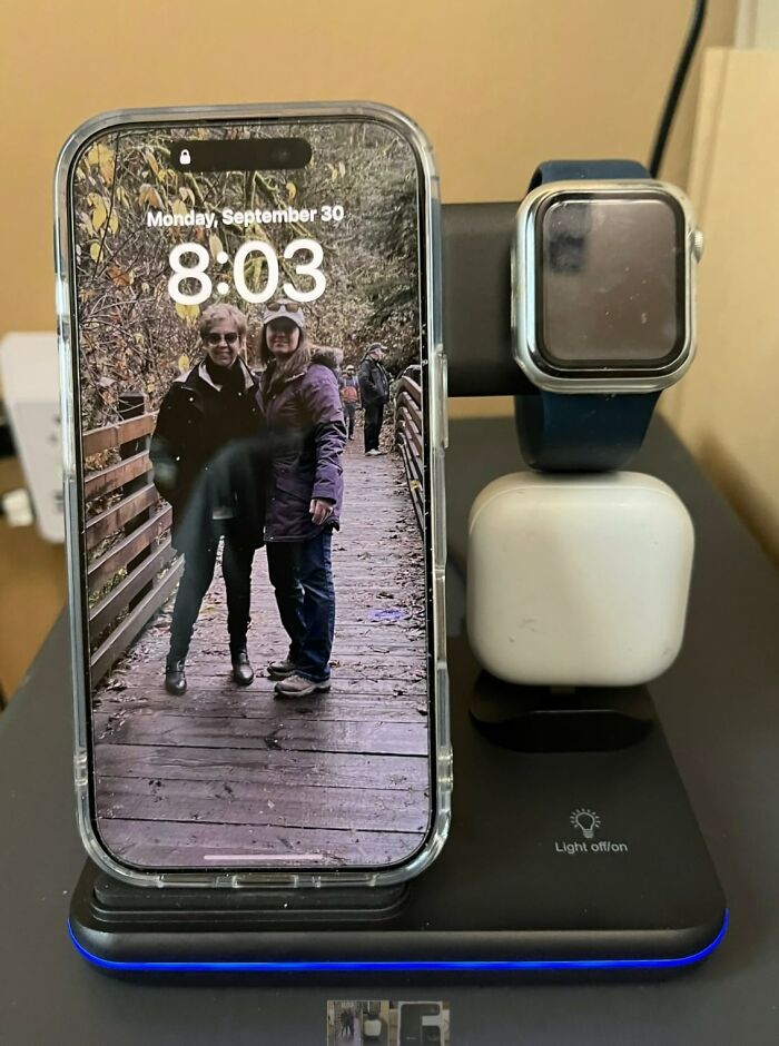 Smart home charging station holding a smartphone, watch, and earbuds, showcasing cool tech products on a desk.