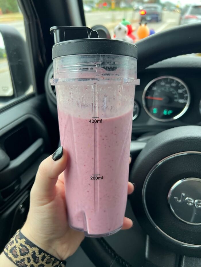 Pink smoothie in a clear travel cup, ideal for efficient meal prep on-the-go.