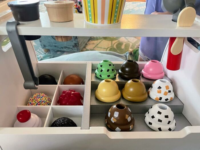 Wooden toy ice cream scoops and cones arranged in a playset, popular toys kids genuinely can't get enough of.