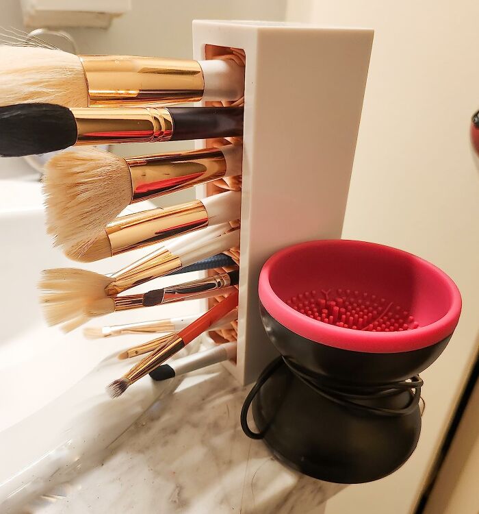 Organized makeup brushes in a holder and a brush cleaning tool, showcasing practical time savers for quick beauty routines.