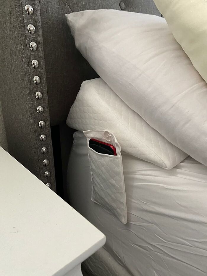 Bedside pocket holding a phone, a trendsetting treasure that blends style with practicality.