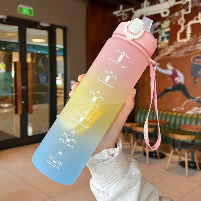Hand holding a colorful water bottle with motivational time markers, featured in a popular Amazon haul finds collection.