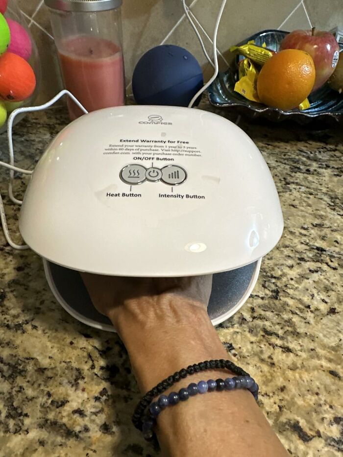 Hand using an electric hand warmer on kitchen counter, a unique Mother's Day gift idea beyond socks.