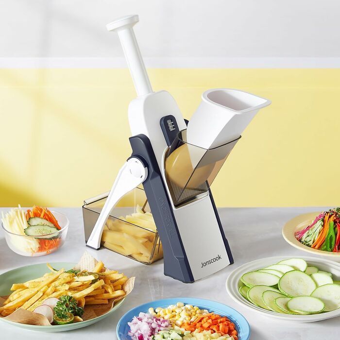 Vegetable slicer on a kitchen counter with neatly arranged meal prep ingredients.
