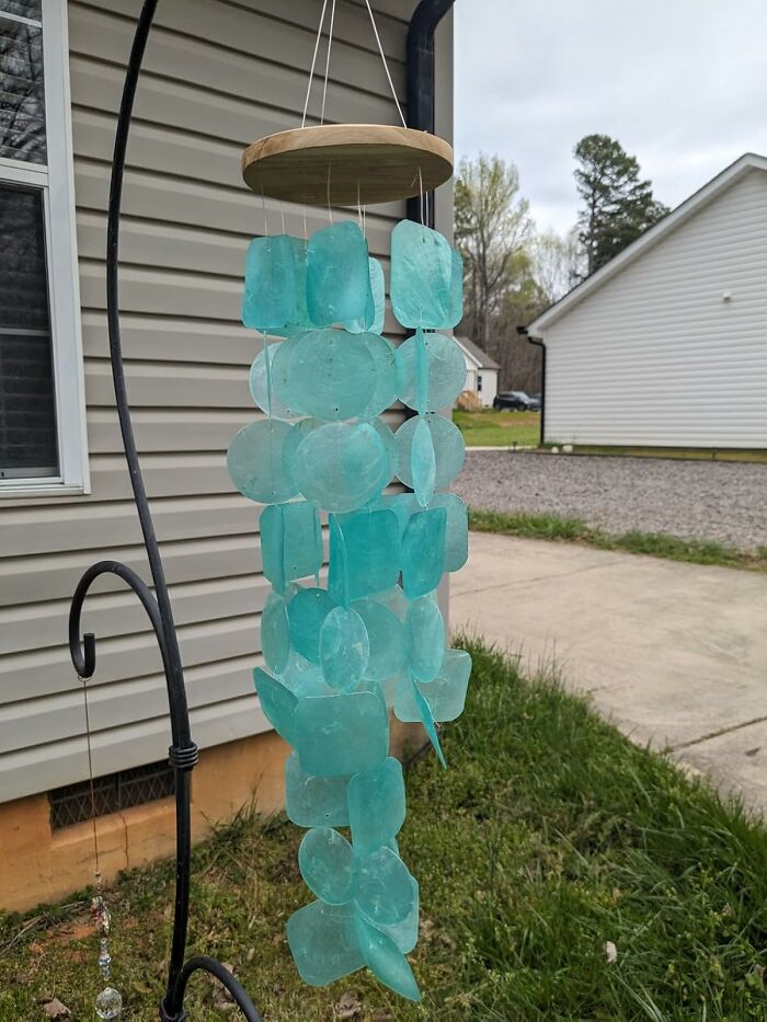 Blue hanging wind chime outdoors, a unique Mother's Day gift idea beyond typical socks.