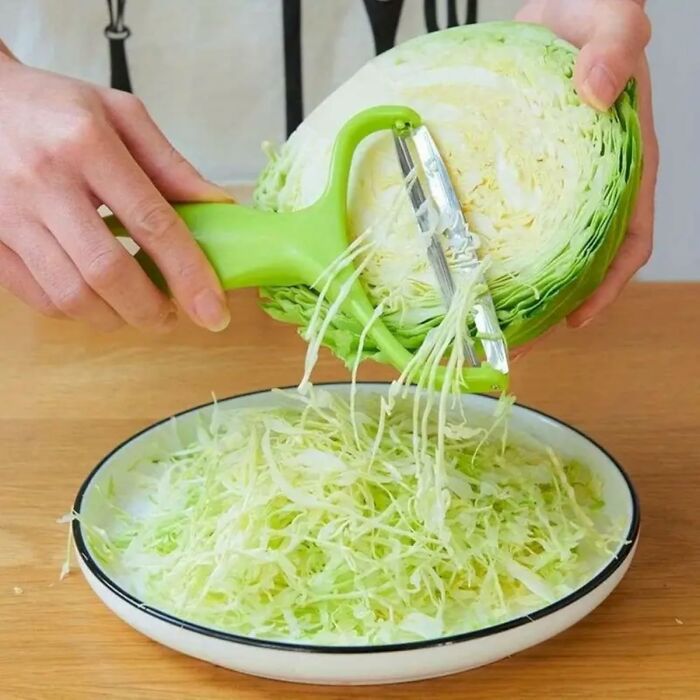 Hands using a green peeler to shred cabbage into a white bowl, showcasing kitchen deals from Amazon haul.