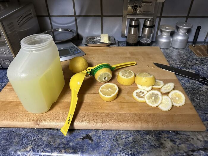 Lemon squeezer and sliced lemons on a cutting board for efficient meal prep.