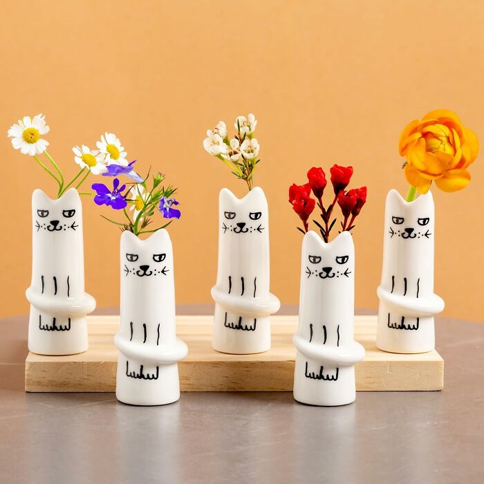 Cat-themed vases with flowers, ideal for work supplies decor on a wooden shelf.