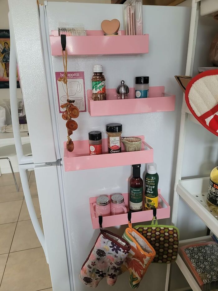 Pink magnetic shelves on a fridge holding spices and kitchen essentials, showcasing popular Amazon movers and shakers.