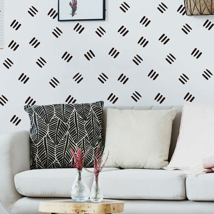 Modern apartment decor with patterned cushions and wall design, adding style to the space.