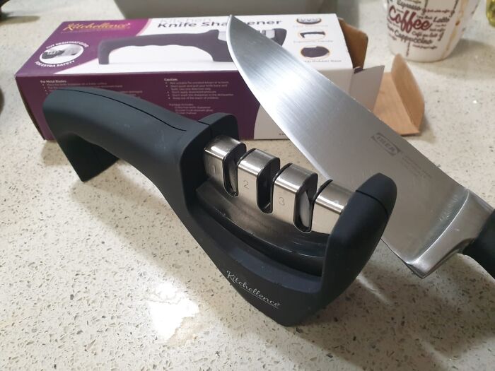 Knife sharpener with a kitchen knife on a countertop, perfect for making Wednesday tasks easier and more efficient.