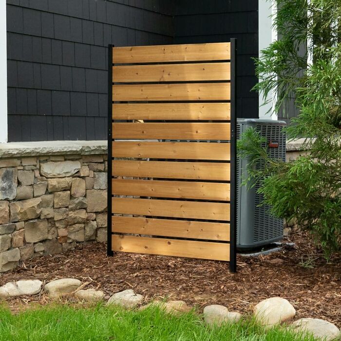 Wooden privacy panel beside air conditioning unit, a popular item on Amazon.