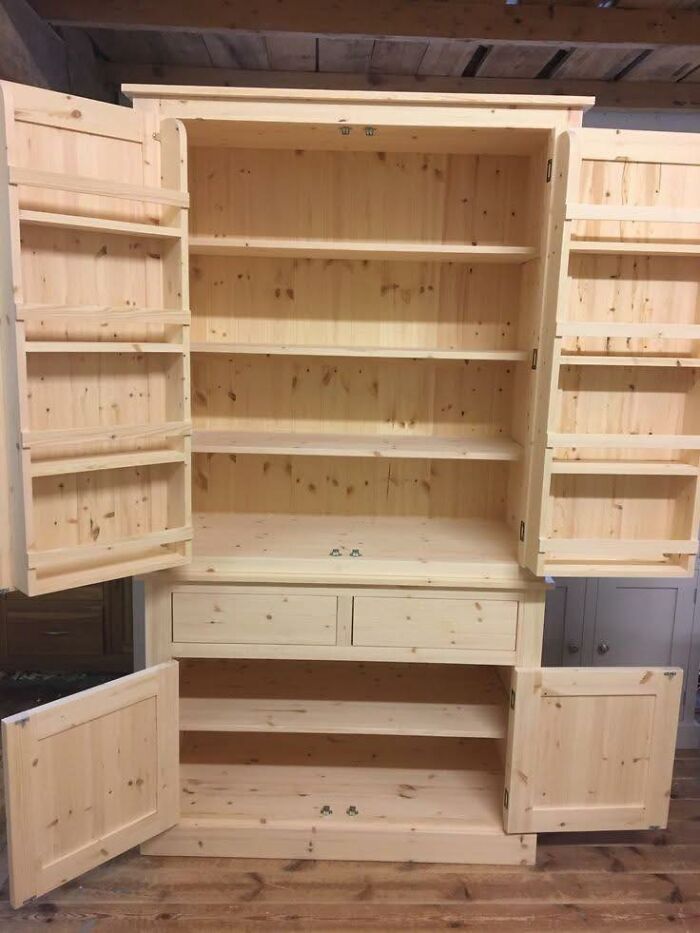 Armario de madera hecho a mano con puertas y estantes abiertos, muestra habilidades en proyectos de madera.