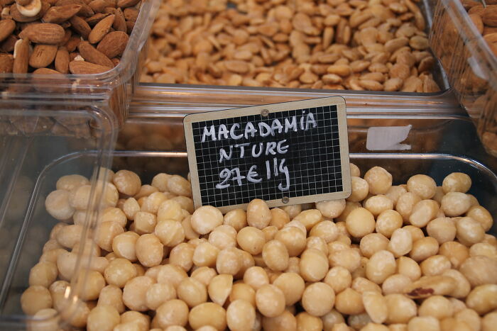 Macadamia nuts displayed in clear containers at a market, highlighting restaurant food cost concerns and price increases.