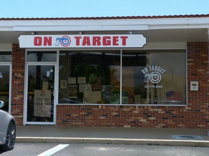 American gun store facade with brick exterior and signs, highlighting cultural differences.