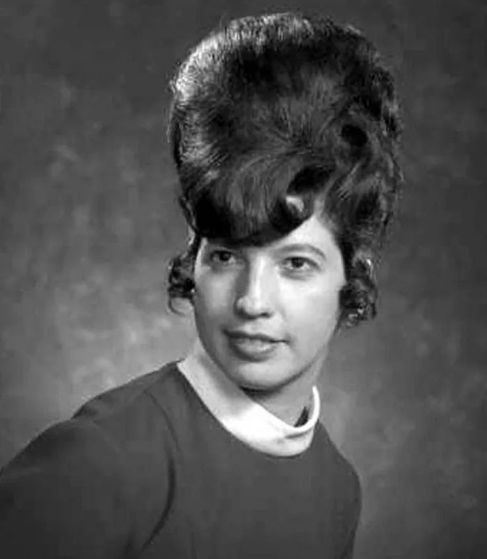 A woman with an elaborate vintage hairstyle, showcasing absurd and amazing fashion from yesteryear.