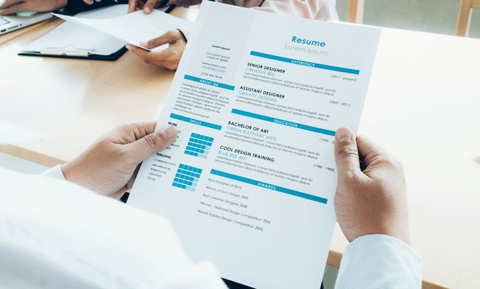 Person holding a resume at a job interview, highlighting job hunting strategies.