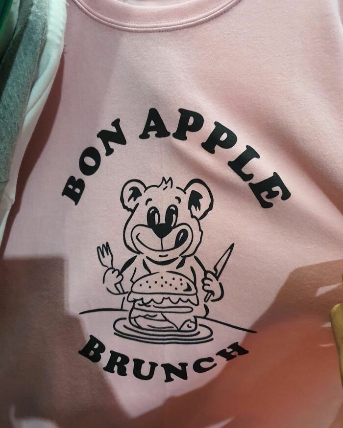 T-shirt with "Bon Apple" humorous text and cartoon bear holding a burger, showcasing translation mishap.