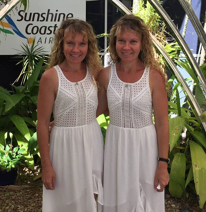 Twins wearing white dresses, standing together at Sunshine Coast Airport amidst lush greenery. Twins wearing white dresses, standing together at Sunshine Coast Airport amidst lush greenery.