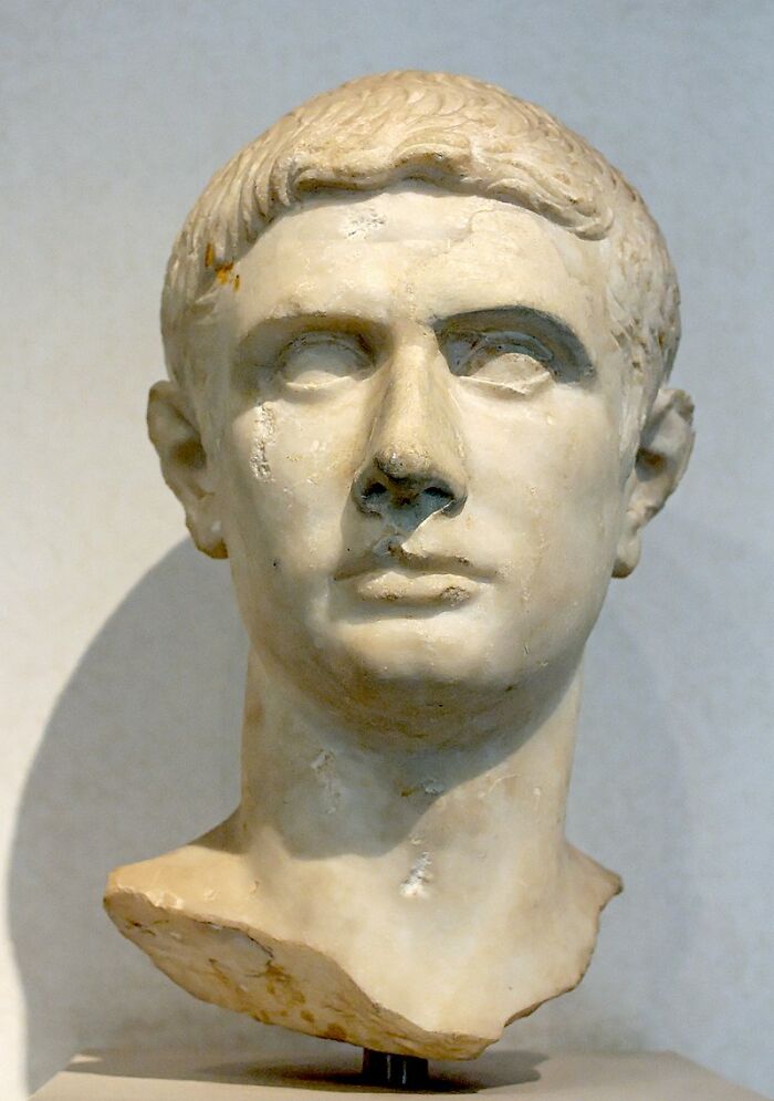 Marble bust of a historical figure, often labeled as a notorious traitor in ancient history, displayed in a museum.